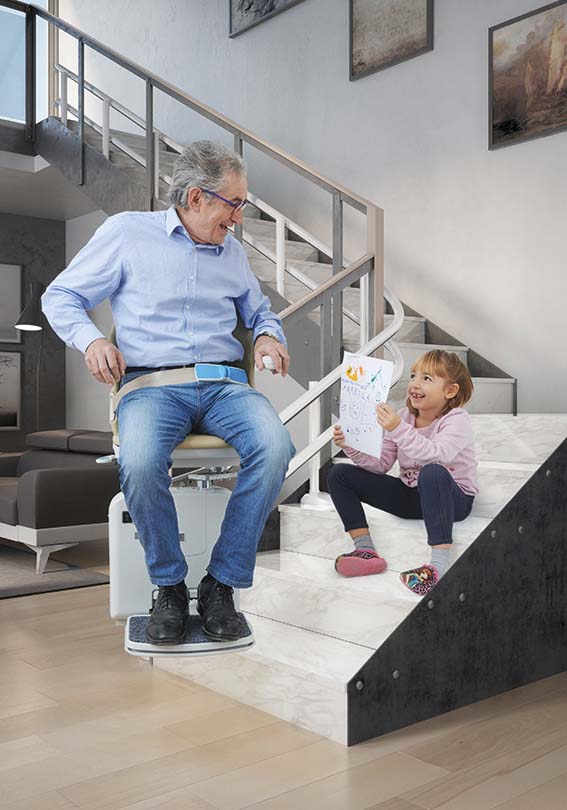 Grandfather with grandchild on his stairlift - Curved Stairlifts